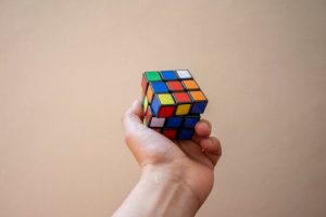 Hand hält einen Rubik’s Cube als Symbol für komplexe Probleme und die Suche nach strukturierten Lösungen