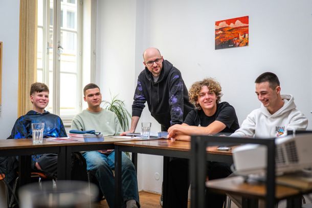 Gruppe junger Menschen im Workshop mit Coach als Symbol für Teamarbeit und gemeinsame Entwicklung