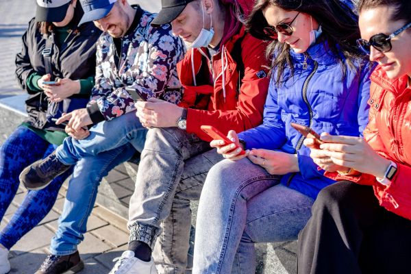 Junge Menschen der Generation Z nutzen Smartphones und digitale Netzwerke im öffentlichen Raum